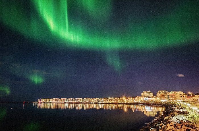 Iceland city with northern lights glowing in the sky