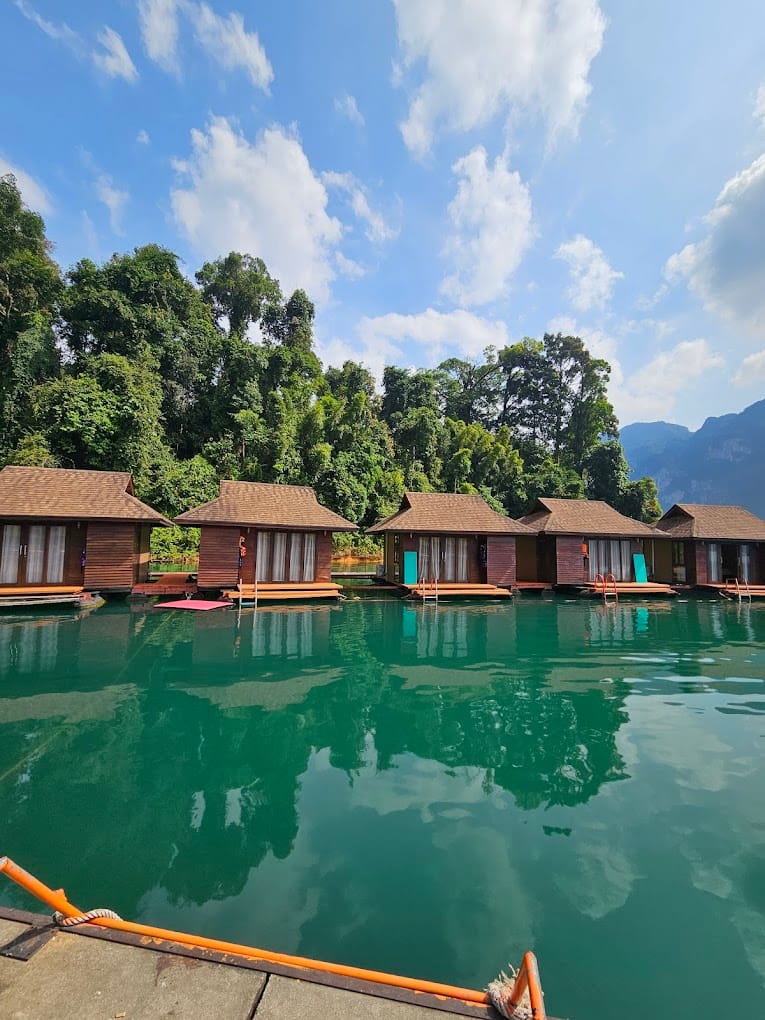 Individual floating bungalows on an emerald lake surrounded by Jungle.