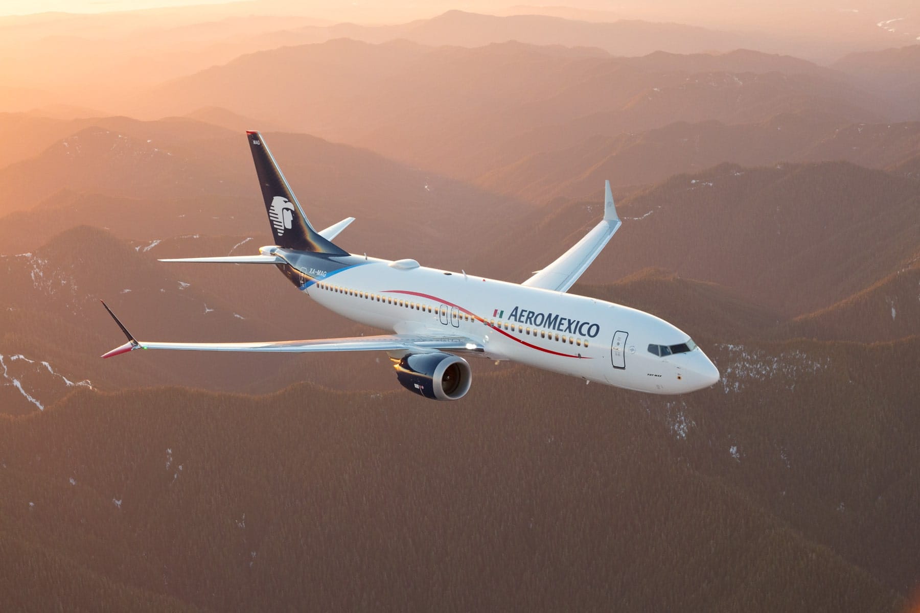 Aeromexico airplane flying over foggy mountains.