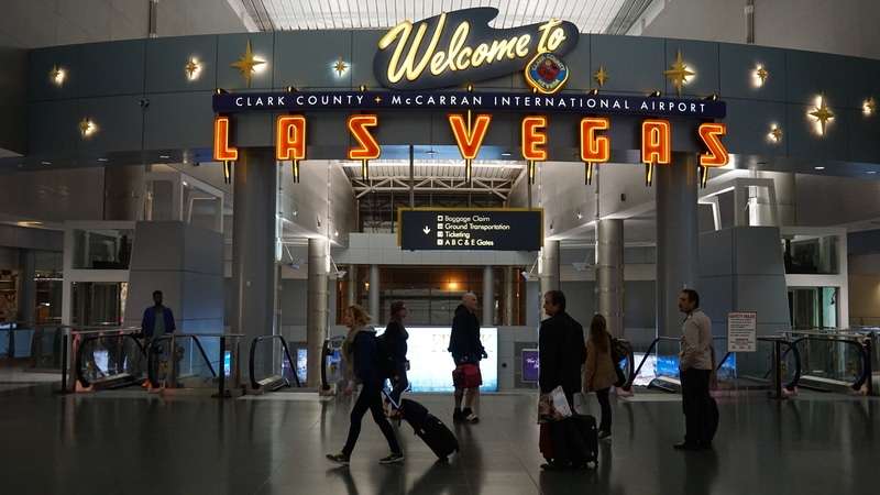 Travelers walking past the iconic “Welcome to Las Vegas” sign inside Harry Reid International Airport (formerly McCarran International).