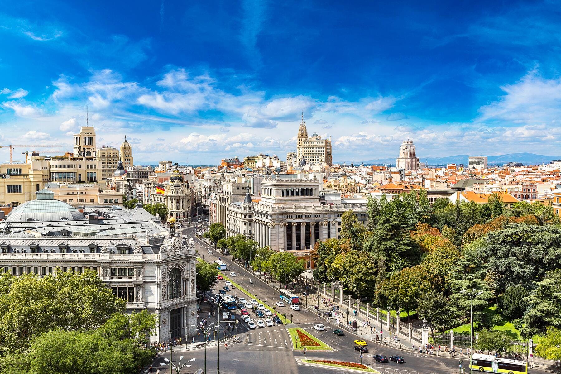 Aerial view of central Madrid with historic architecture, busy streets, and a vibrant skyline.