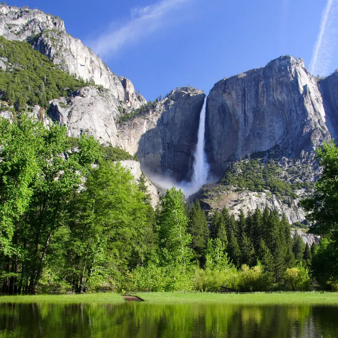 Yosemite Falls tumbling down granite cliffs into a forested valley inside Yosemite National Park, California.