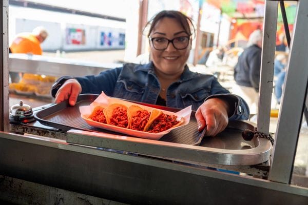 A woman is serving tacos as a food vender at the Arizona Market place in Yuma, Arizona.