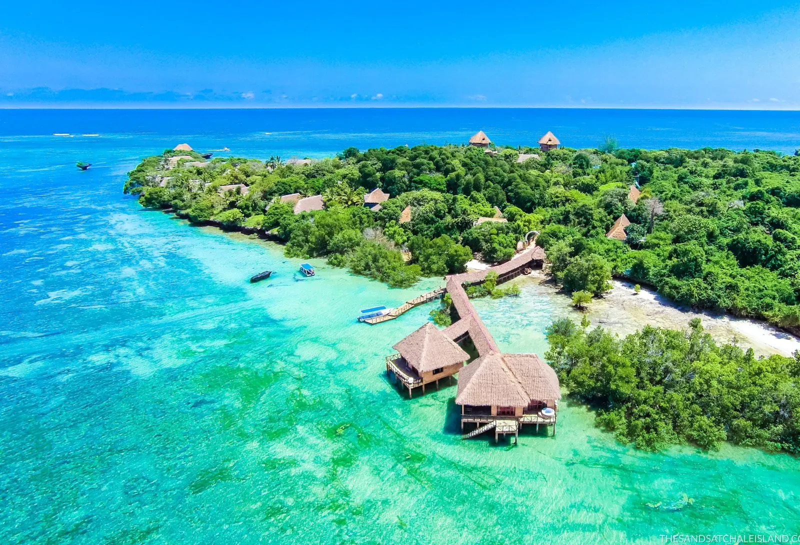 Aerial view of Chale Island in Kenya, featuring turquoise ocean waters, lush greenery, and thatched beachfront villas.