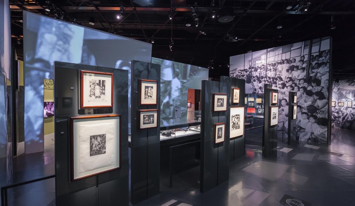 Exhibit at the Museo Nacional de Colombia featuring framed black-and-white prints on modern display panels, with historical photos of Colombian life covering the surrounding walls.