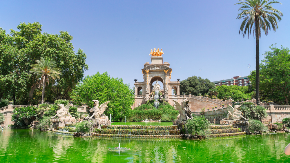 Cascada Monumental fountain in Parc de la Ciutadella, Barcelona, surrounded by lush greenery and ornate sculptures on a sunny day.