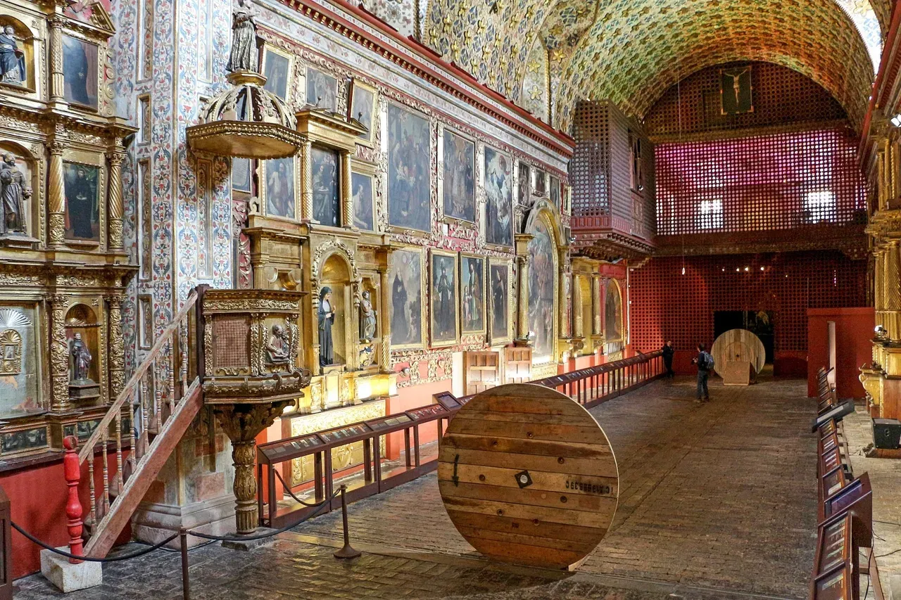 Interior of the Santa Clara Church Museum in Bogotá, Colombia, showcasing ornate colonial-era religious artwork, gilded altarpieces, and vaulted ceilings decorated with floral motifs.