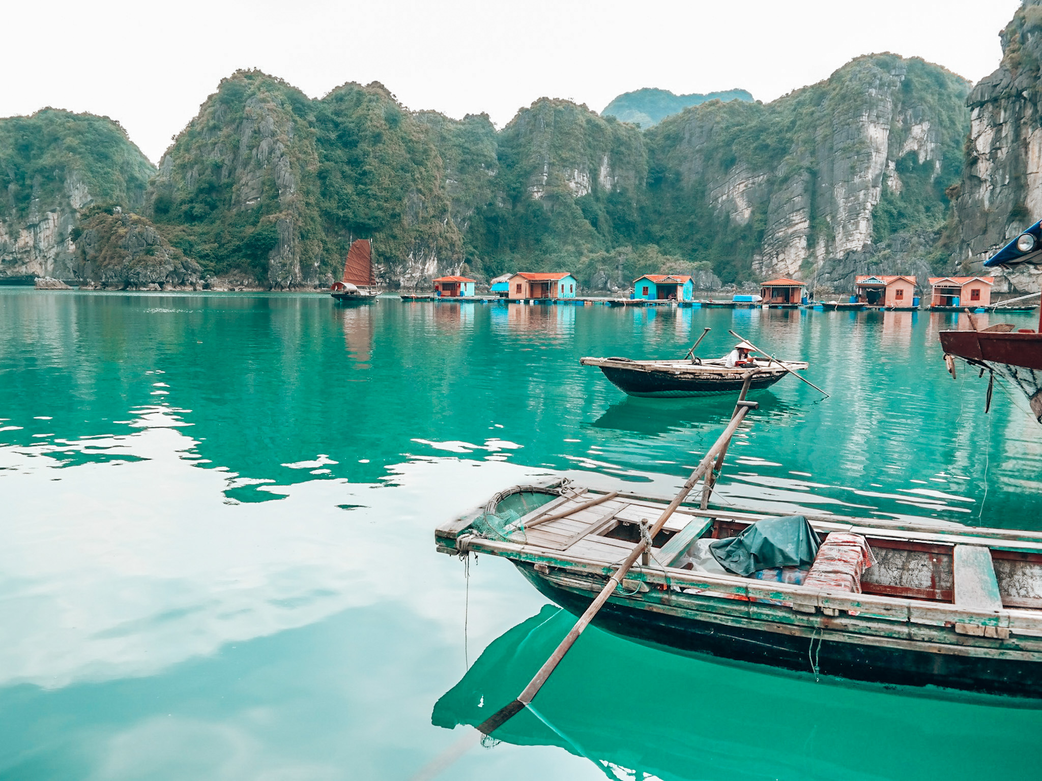 Traditional vietnamese boats on blue waters surrounded by mountains in Ha Long Bay, Vietnam.