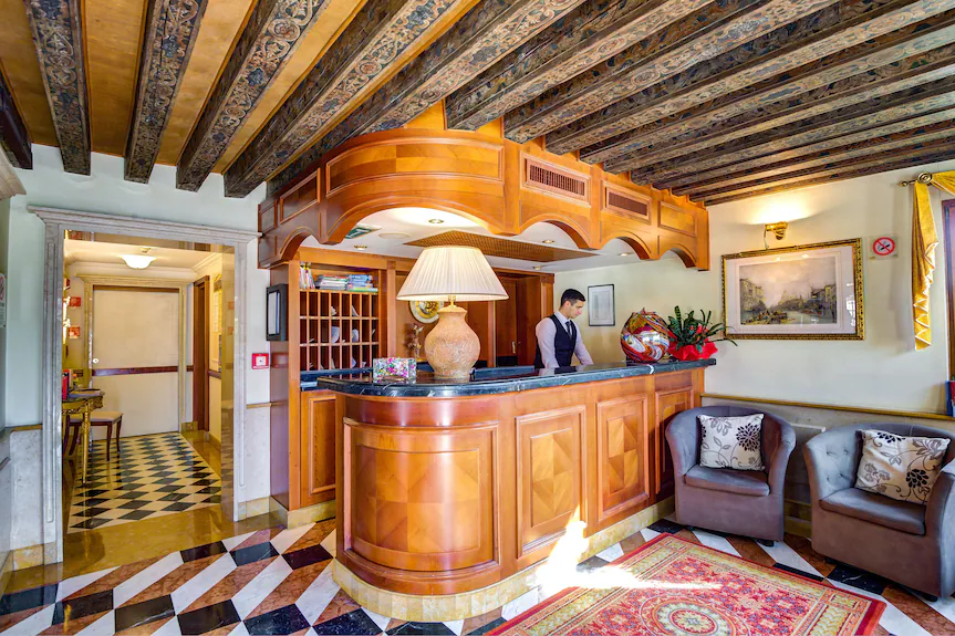 Front desk worker doing check-ons at Hotel Antiche Figure in Venice, Italy.