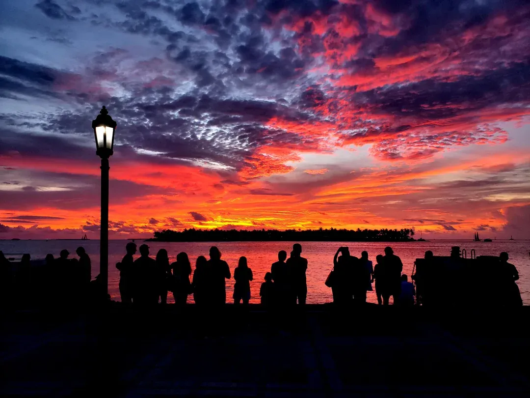 People watching a gorgeous sunset of pink, purple and blue colors in Key West, Florida.