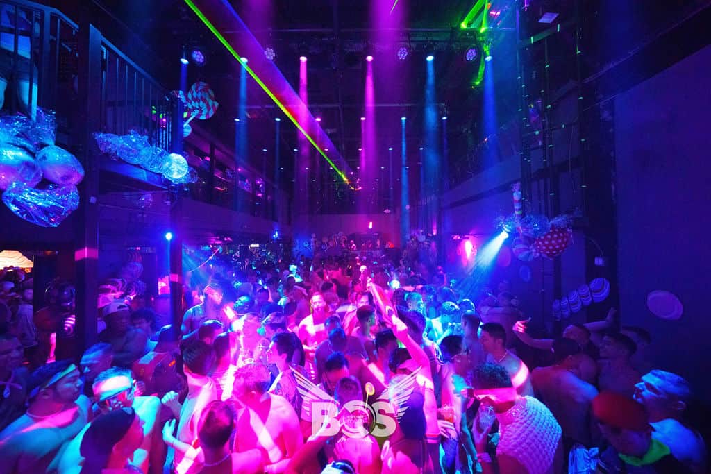 Lot's of people dancing under bright colored lights at the Jungle Nightclub in Negril, Jamaica.