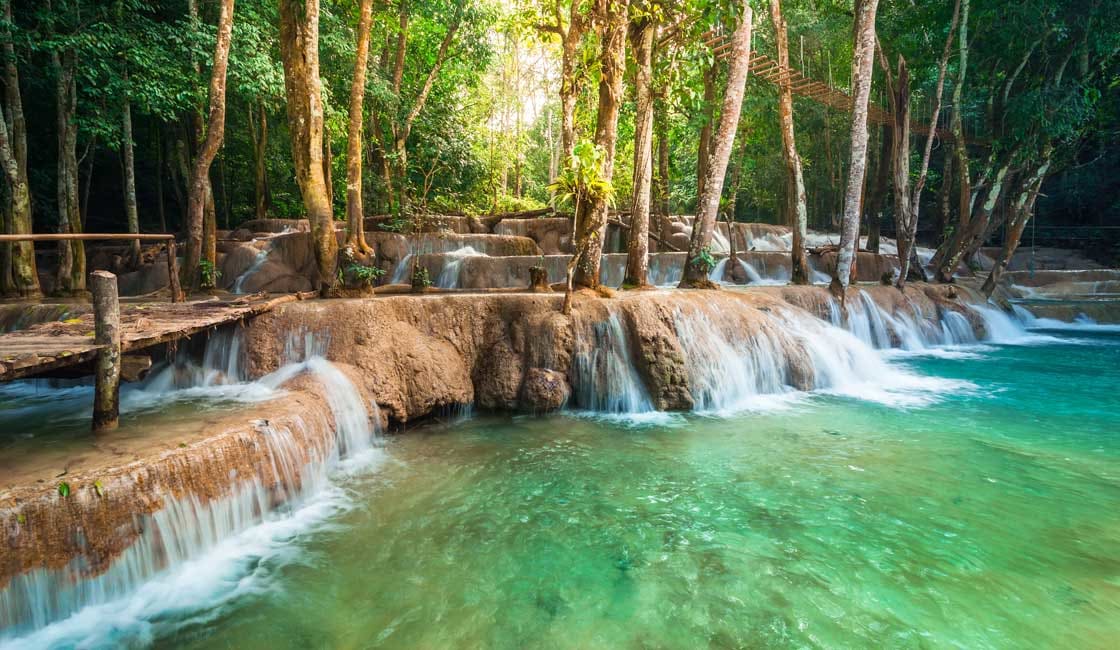 beautiful waterfalls flowing between trees at Kuang si Falls.