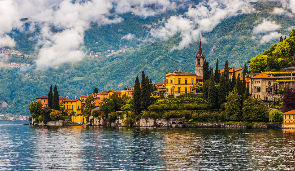 lake como resorts with clouds above it and lake views.