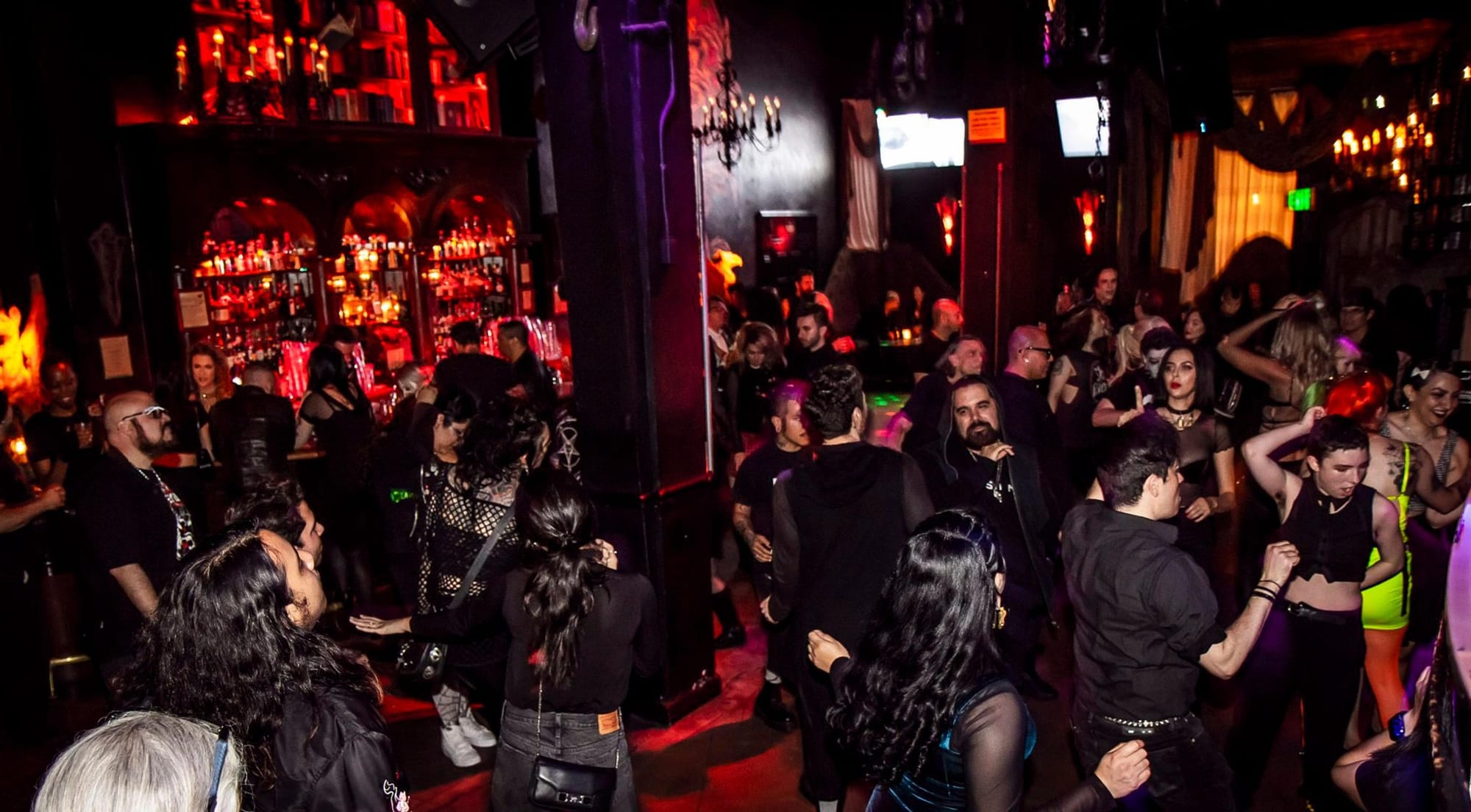 people hanging out and dancing in a club in the gothic quarter barcelona.