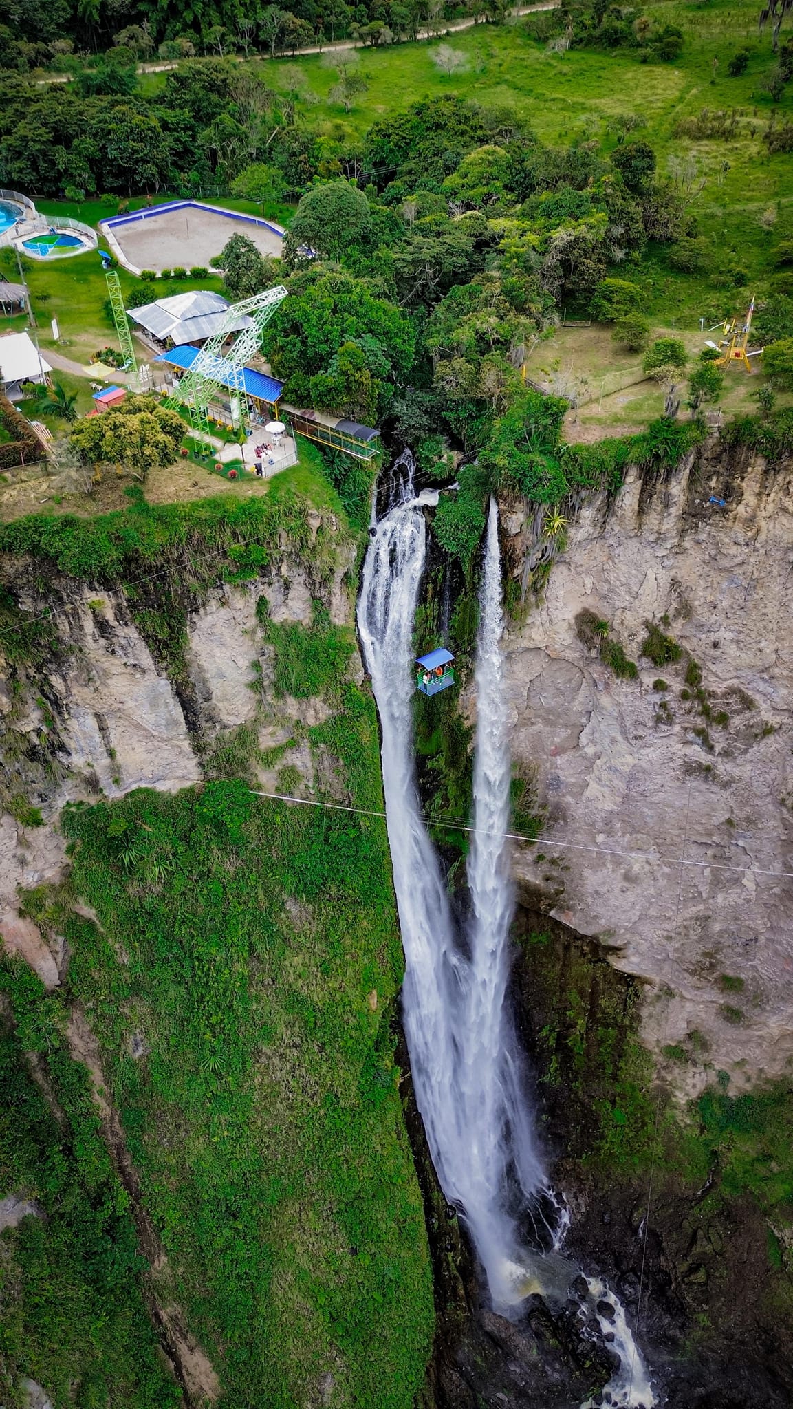 Massive single drop waterfall of Salto del Mortiño in Colombia with bunjee jump platform at the top.