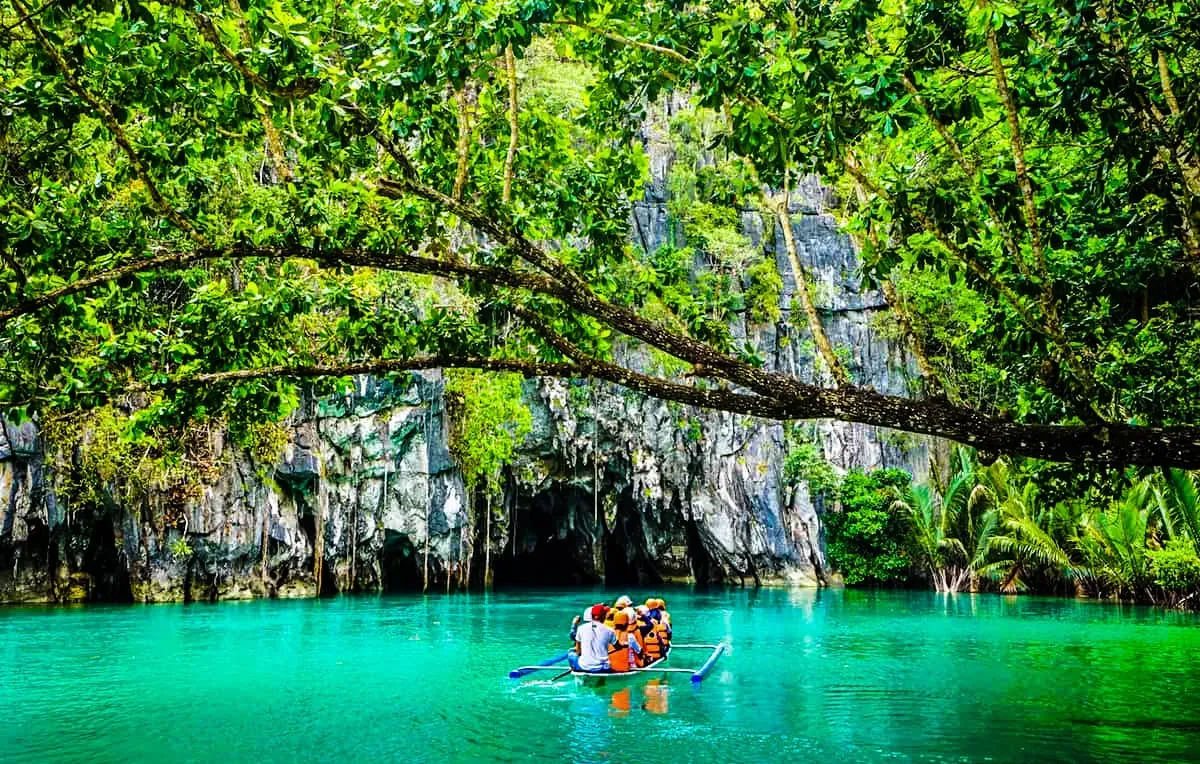 People on a boat near a cave on Puerto Princesa Subterranean River 