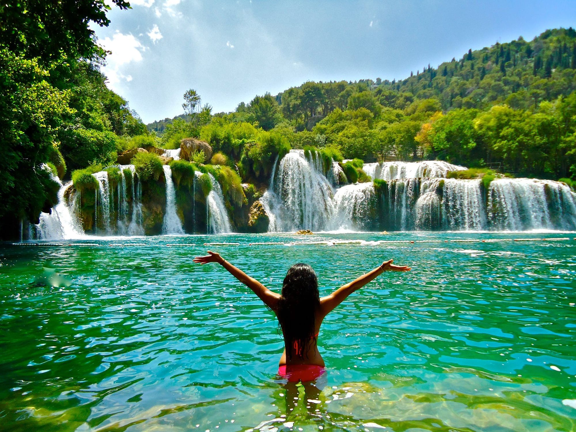 A girl in the water at Skradinski Buk Waterfall in Krka National Park, Croatia.