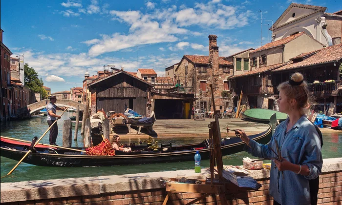 A woman painting near the water in Dorsoduro neighborhood in Venice, Italy.