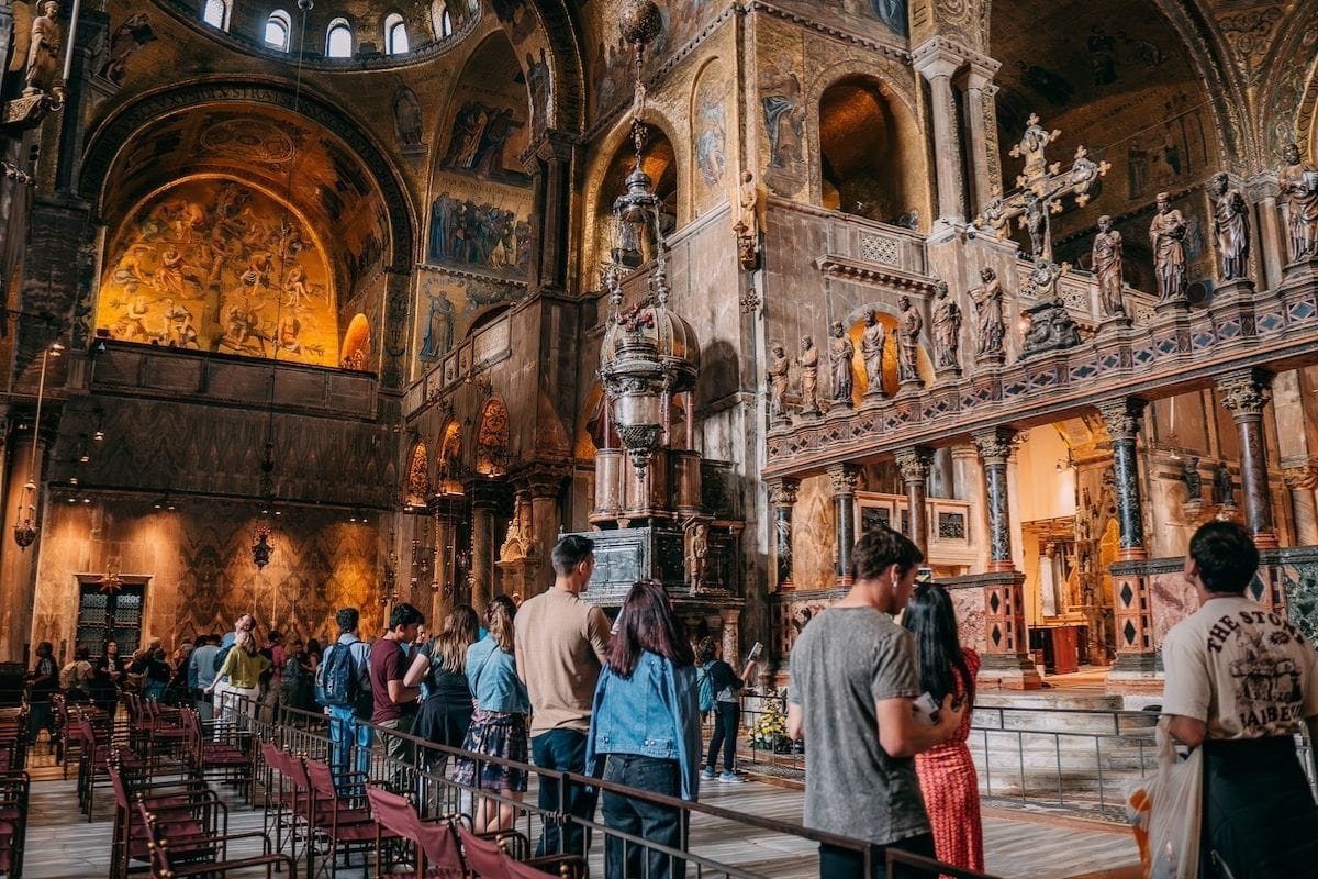People on a guided tour inside St. Mark's Basilica in Venice, Italy.