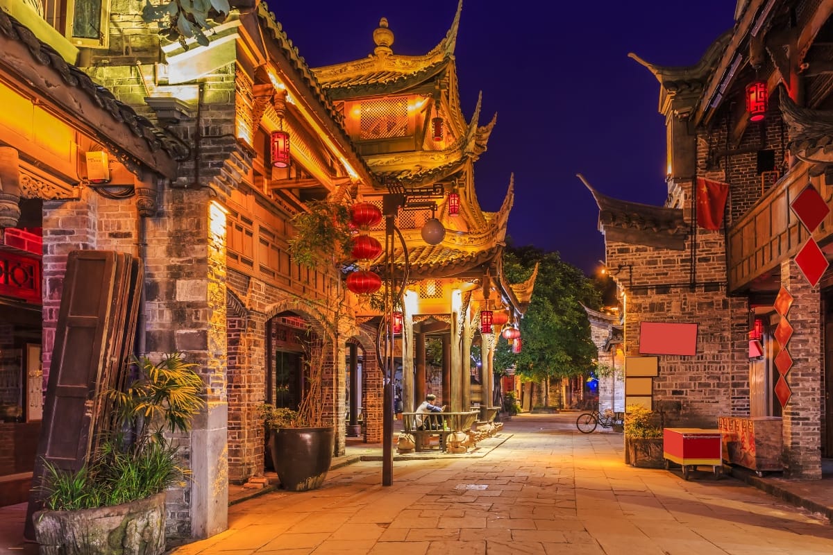Old streets and buildings lit up at night in Chengdu, China.