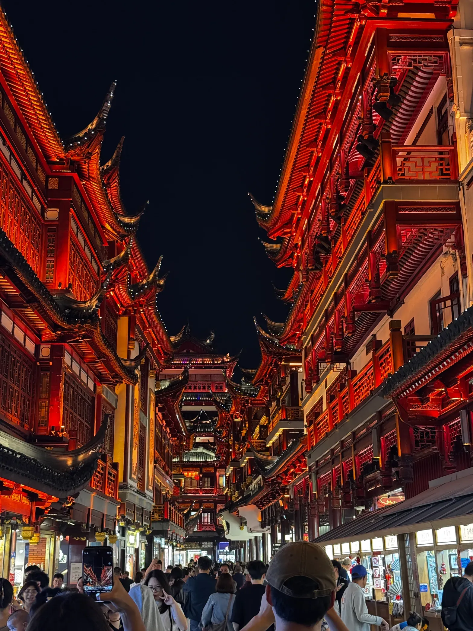 People walking around at night in Shanghai, China taking photos of the cool looking buildings.