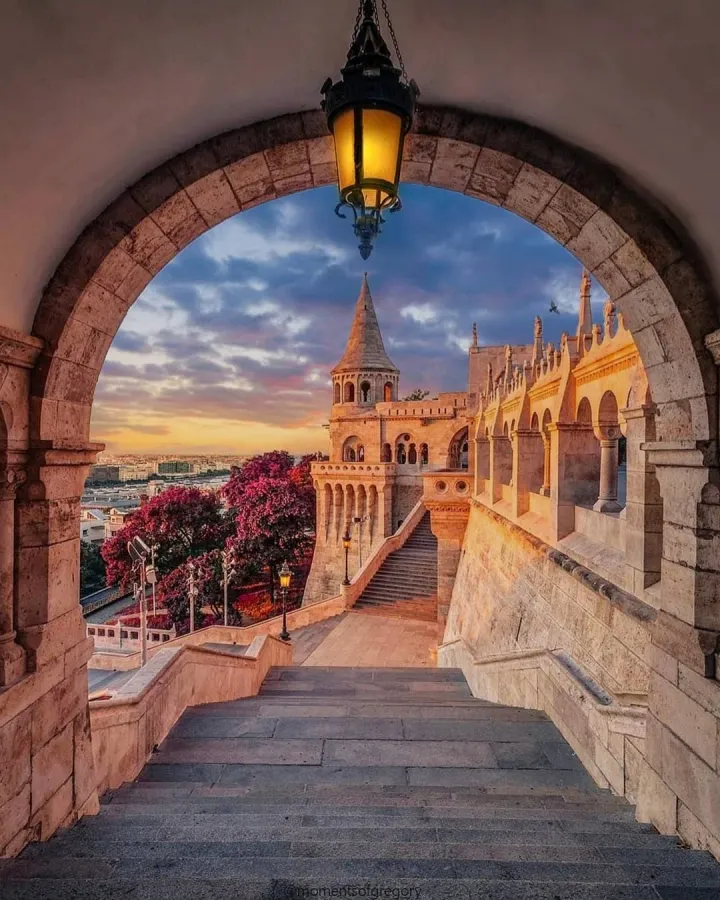 Stairs leading down Fisherman's Bastion with fall colored trees and a beautiful sunset in Budapest.