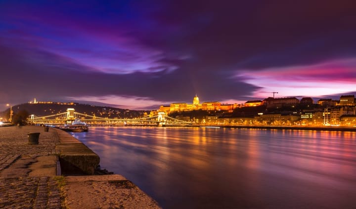View of the The Danube River from the Danube Promenade in Budapest at Night with parliament building lit up. 