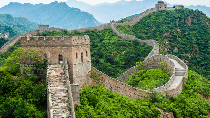 The Great Wall of China winding along a mountain peak with fortresses built along at the top of each peak.