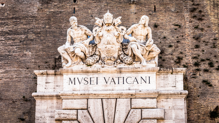The entrance to the Vatican Museum  is a white rock door on the side of Vatican wall.