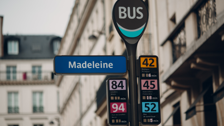 A street sign in paris for a bus stop.
