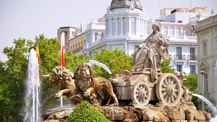 Statue of woman being pulled by two lions sits at the center of a fountain in Madrid, Spain.