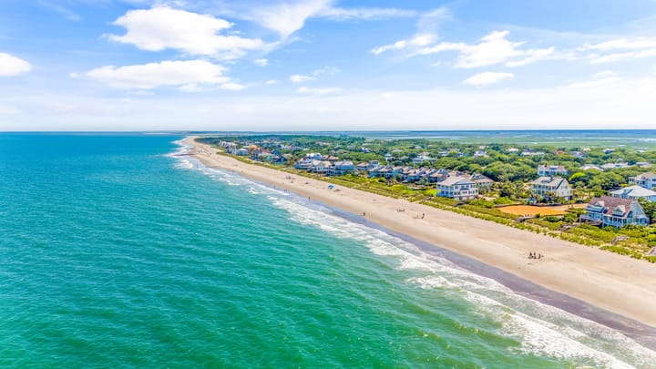 Beautiful Debordieu Beach with waves washing ashore with large houses lining the beach.