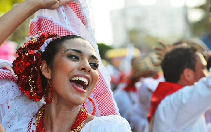A woman celebrating a festival in Bogota, Colombia dancing in the streets.