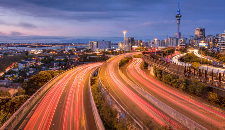 A highway in Auckland, New Zealand with a view of the city at night.