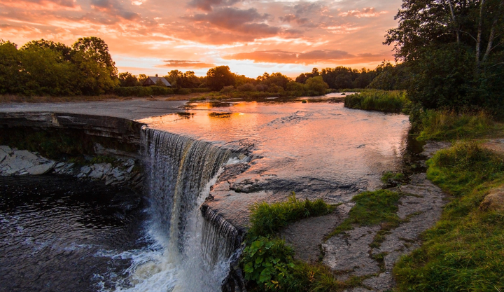 Sunset at a river with a small waterfall surrounded by jungle in Guyana.