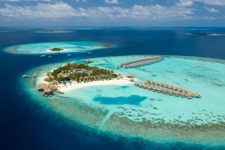 Beautiful private island beach resort with overwater bungalows in the Maldives.