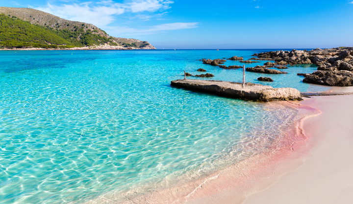A beach in Spain with crystal clear blue waters.