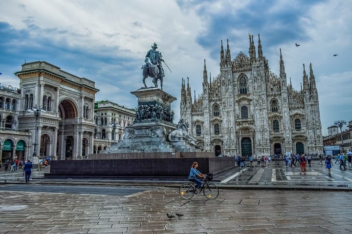 Riding a bik in Milan, Italy in front of a cathedral. 
