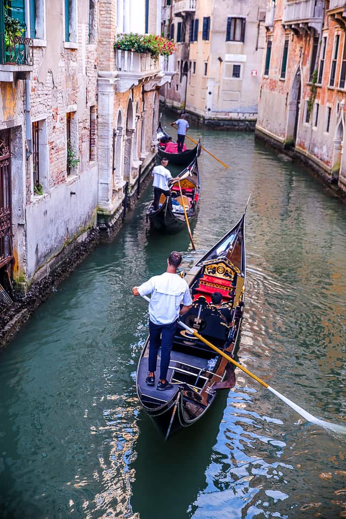 People taking a Gondola Ride on a canal in Venice, Italy.