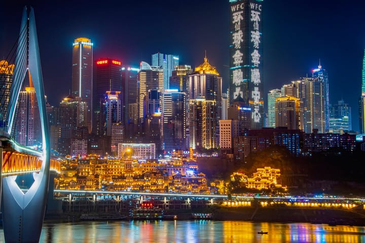 Chongqing City Skyline At Night, with Modern High Rises Lit Up With Bright Lights.